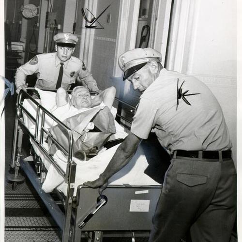 [Ambulance attendants moving a patient from the old French Hospital building into the new one]