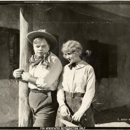 [Publicity still featuring Roscoe "Fatty" Arbuckle and Jane Acker in "The Roundup"]