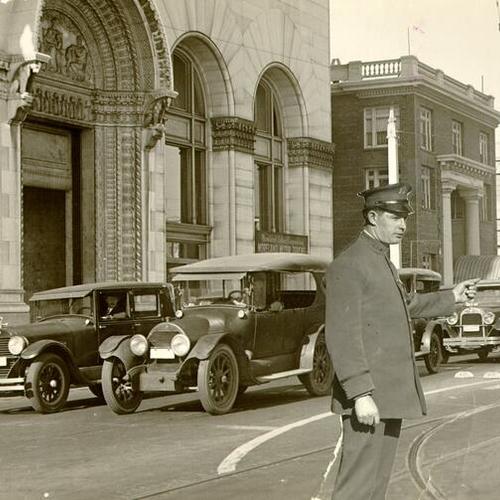 [Photo of Van Ness Avenue at Market with photo of police officer directing traffic superimposed on top]