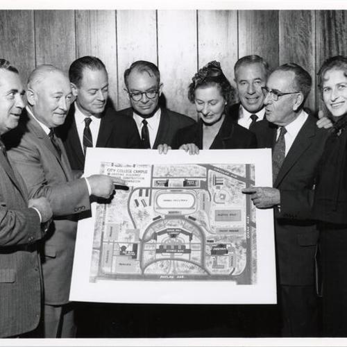 [Group of unidentified people holding plans for City College expansion project]