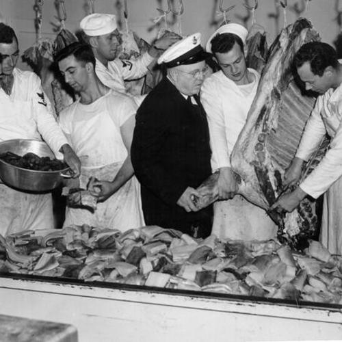 [Chief Commissary Stewart I.M. Wallace and his crew looking over supper in the making at the Navy's butcher shop]