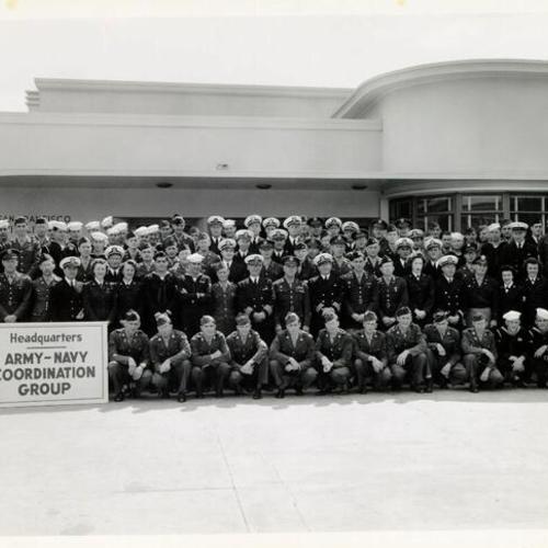 [Army-Navy Coordination Group posing for a photograph in front of the Hospitality House]