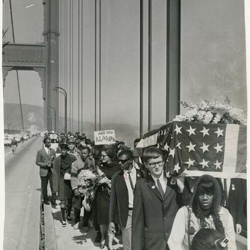 Demonstrators carrying flag-draped casket across Golden Gate Bridge