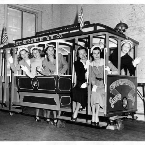[Mrs. Frank Hinman, Miss Ella Anderson, Mrs Philip Robertson, Miss Sharon Wells, Miss Nancy Majors and Mrs. William Bush standing in a model cable car made for a youth fair]