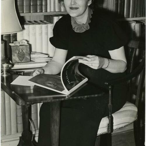 Marion Dorn sitting at her desk reading