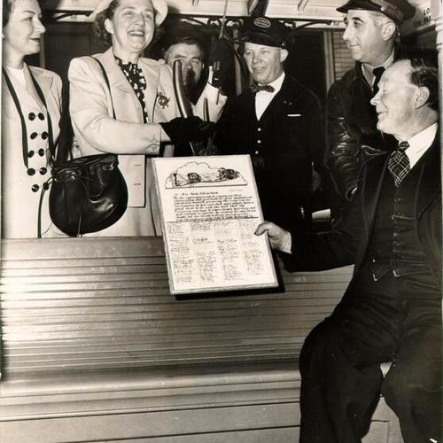 [Mrs. Hans Klussmann receiving a letter of appreciation from employees of the California Street Cable Railroad Company]