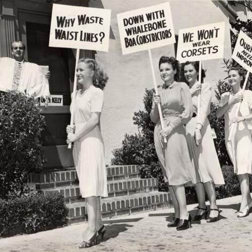 [Priscilla Lane, Lola Lane, Gale Page and Rosemary Lane picketing Orry-Kelly studio fashion designer for helping bring corsets back into fashion]