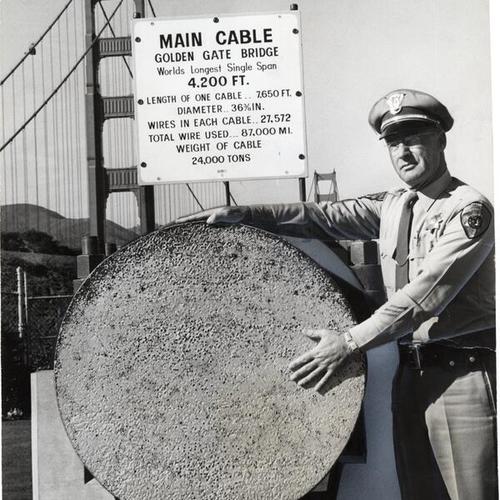 [T. Allyn Bragg standing next to main cable and Golden Gate Bridge is in background]