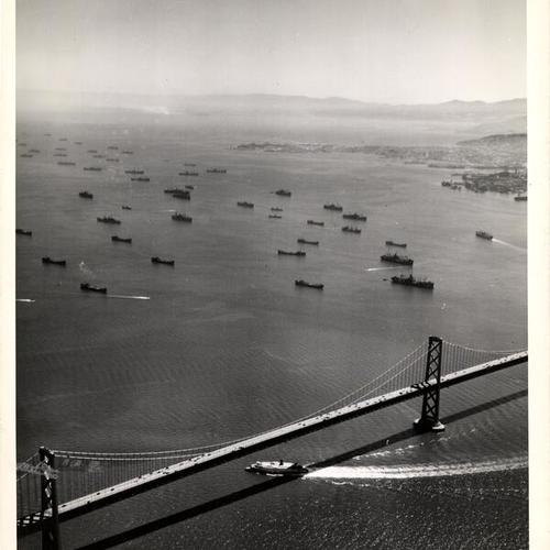 [Flotilla of U.S. Navy ships pass under Bay Bridge prior to exiting Bay]