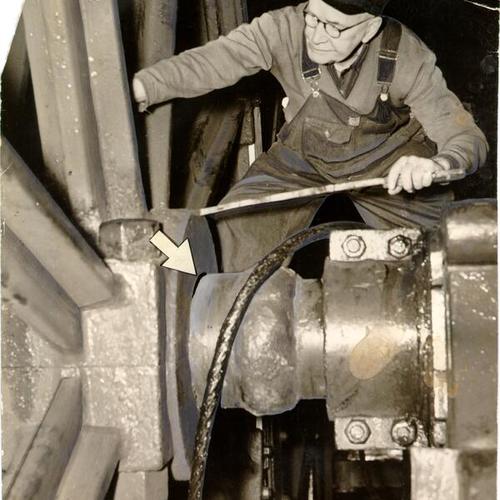 [Unidentified man working on cable at cable car powerhouse]