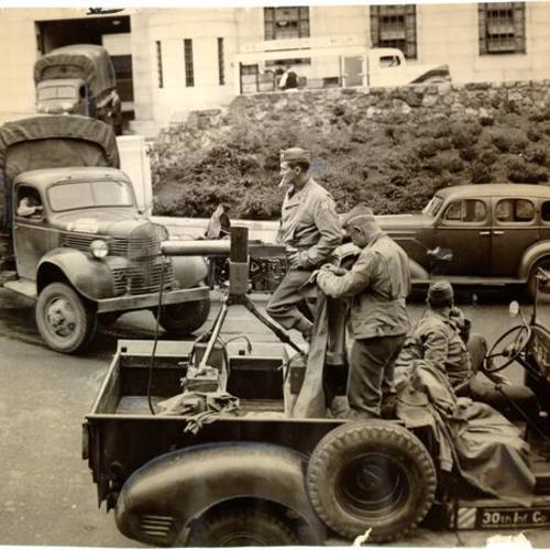[U. S. Army removing truck loads of money from the Mint building at Market, Buchanan and Duboce streets]