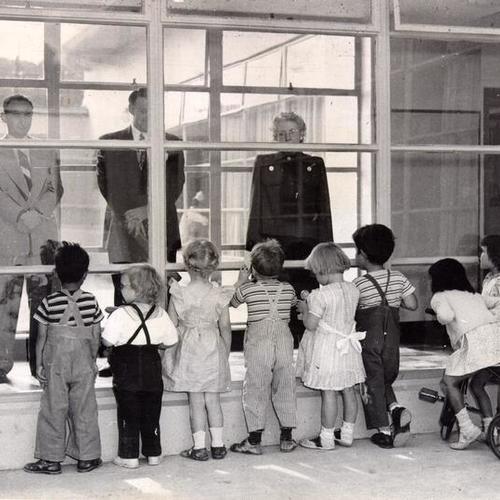 [Children staring out the window of a play area at the Youth Guidance Center]