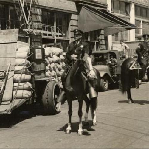 [Mounted police guarding delivery trucks at the Euclid Candy Company during strike]