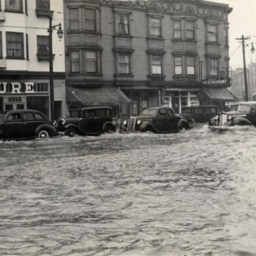 [Cars wading through water, due to heavy rains, at the intersection of Market, Church and 14th Streets
