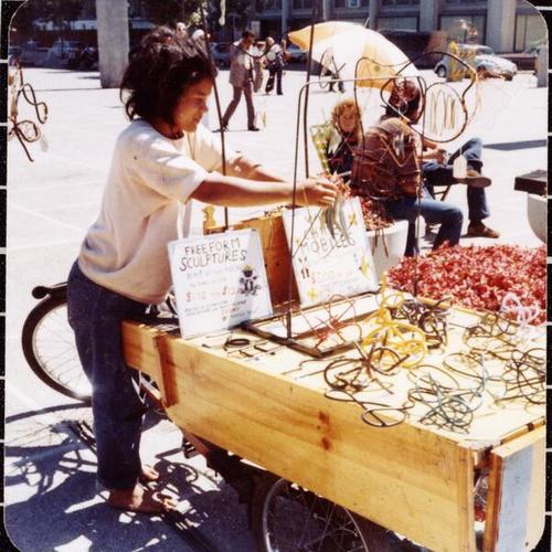 [Melinda at Justin Hermann Plaza selling sculptures she made and transported with her rickshaw]