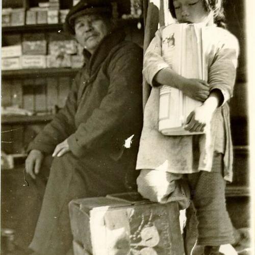 [Unidentified man and young girl outside of a store in Chinatown]
