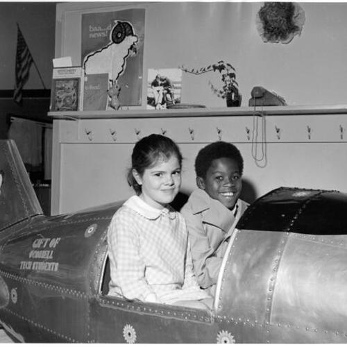 [Le Conte students sitting in model aircraft, gift from O'Connell Tech students]