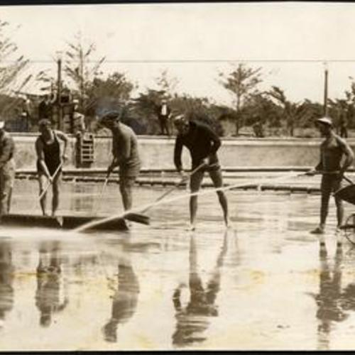 [Tony Ricci (left), Frank Schavo (right) and other men cleaning floor of Fleishhacker Pool]
