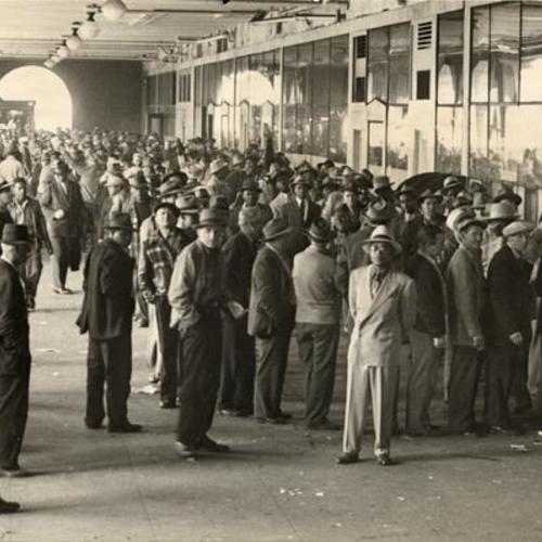 [Longshoremen lined up at the Ferry Building to collect retroactive pay increases]