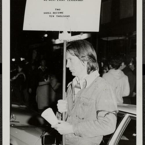 Ted Aldrich holding sign at start of first candlelight march for Harvey Milk and George Moscone