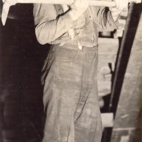 [Jack O'leary, San Francisco-Oakland Bay Bridge workman, digging inside Yerba Buena Island tunnel with a mattock]
