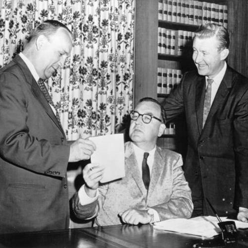 [Governor Edmund G. Brown, center, hands Assemblyman Vincent Thomas (D-San Pedro) the signed copy of a bill exempting ships over 50 tons from taxation during construction]