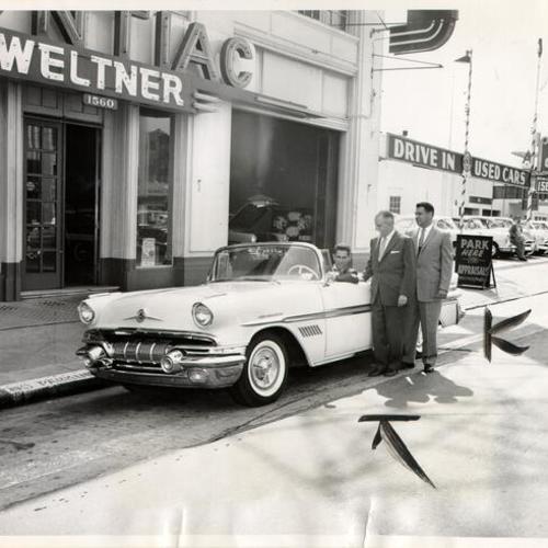 [Les Feria, George D. Dennis and Carter Corey examining a new Pontiac Bonneville Special at Weltner Pontiac dealership]