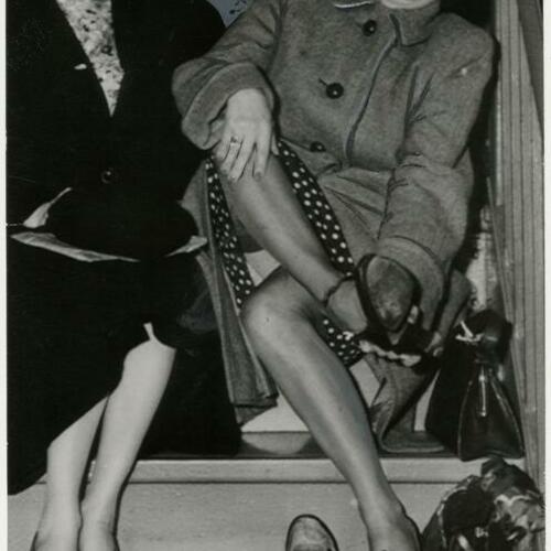 Census takers Mary Wilson and Jeanette Rowatt sitting on stairs changing shoes