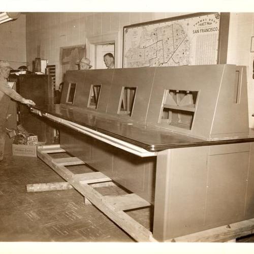 [Workmen transporting the new radio broadcasting console for the Communications Room in Old Hall of Justice]