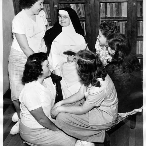 [Sister Mary with a group of girls in the library at the Home of the Good Shepherd]