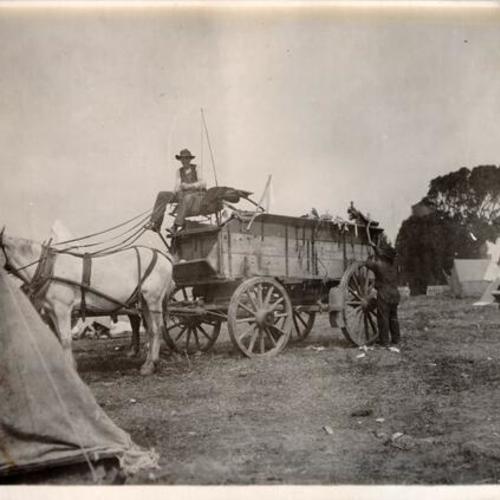 [Two men with a horse drawn wagon at an unidentified refugee camp]