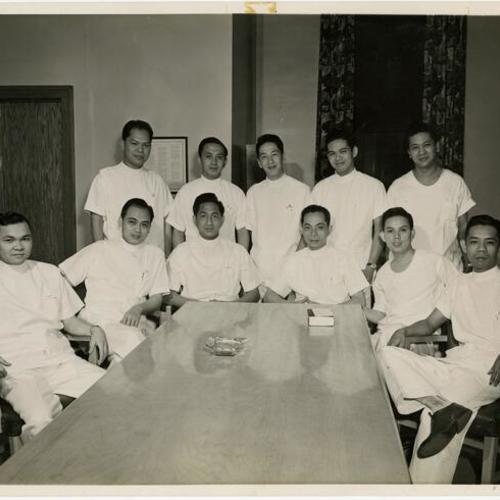 [Group of Filipino resident doctors sit around a table at Franklin Hospital]