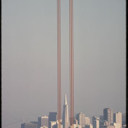 San Francisco skyline view through Golden Gate Bridge cables