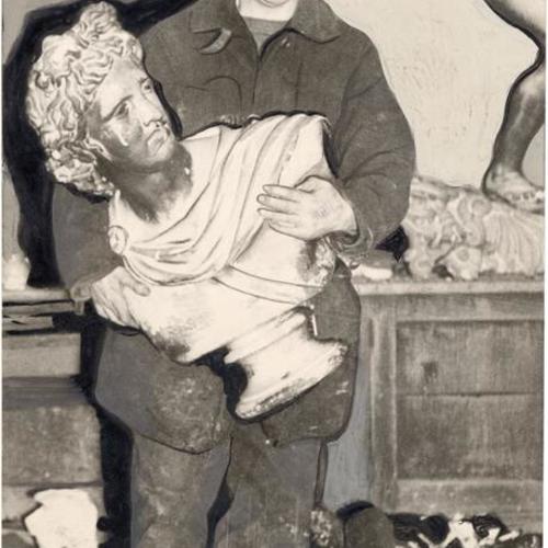 [Fireman El Aitkeb carrying a bust of Apollo from the site of a fire at Lowell High School]