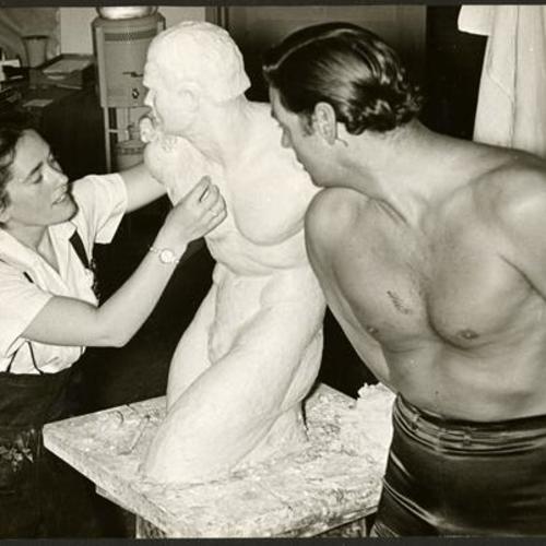 [Mary Hennessy, sculptor and Johnny Weissmuller posing for statue]