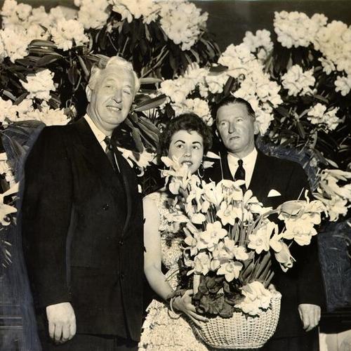 [Edward Goeppner, Donna McCormick and Ernest L. Malloy posing with a floral display from Macy's annual Easter Flower Week exhibit]