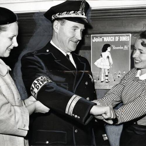 [Mrs. Haurat, area chairman, and Mrs. Valdespino, chairman of the Mother's March on Polio with Deputy Police Chief Thomas Cahill]