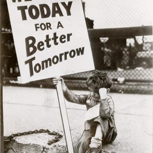 [Young boy holding a picket sign reading "We Fight Today For A Better Tomorrow"]