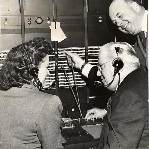 [Mayor Elmer Robinson inspecting switchboard in Pacific Telephone and Telegraph Company building at 25th and Capp streets]
