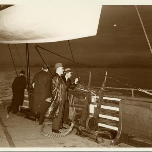 [Passengers standing on rear deck of ferry]
