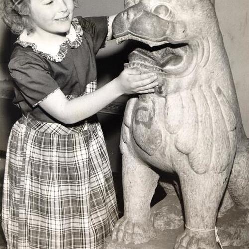[Vicky Anne Hawkins playing with a stone temple lion at Gumps]