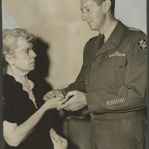 [General Mark Clark presenting Purple Heart to Mrs. Pearl Caligari]