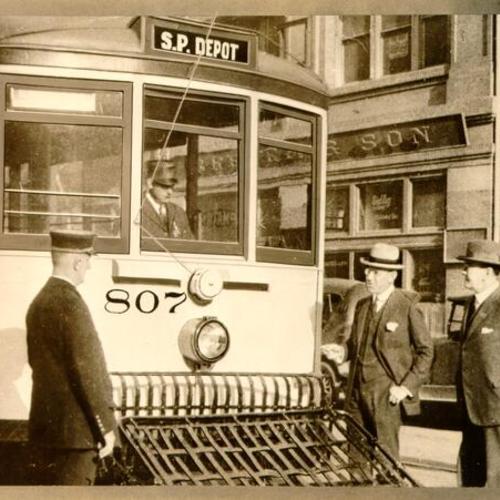 [Market Street Railway Company Executive Vice-President Samuel Kahn showing a new safety feature of his company's streetcars to Fire Chief Murphy and Police Chief O'Brien]