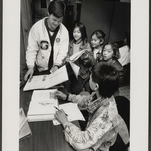 Children receiving homework help from Dean Saelao at the Southeast Asian Chinese Church and Study Center