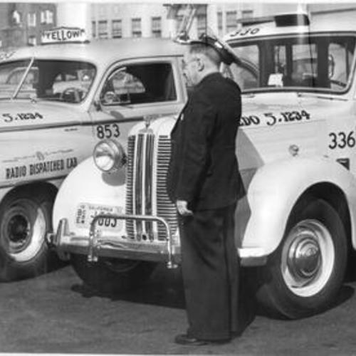 [Yellow Cab Company president W. L. Rothschild and driver Joseph Crowe standing next to two of the company's taxicabs]