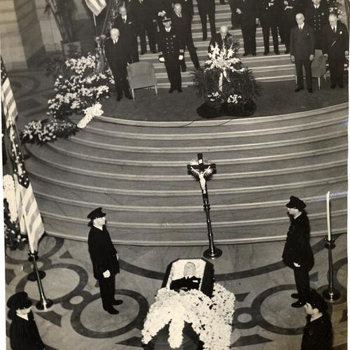 [Body of Alfred J. Cleary lying on a flower-covered catafalque in rotunda of City Hall]