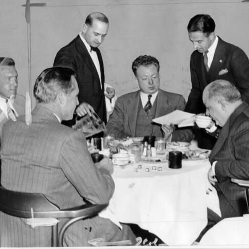 [Peter Pinoni, co-owner of the St. James Restaurant, discussing the dessert menu with a group of diners]