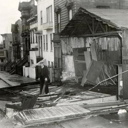 [Al Simon standing in front of his wind damaged cabinet shop at 2555 Post Street]