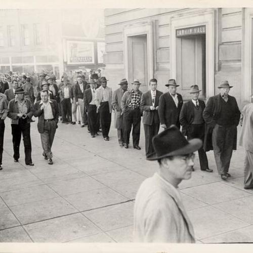 [Waterfront workers lined up outside Civic Auditorium for a union meeting]