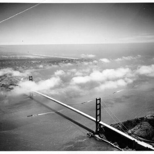 [Aerial view of a submarine passing underneath the Golden Gate Bridge]